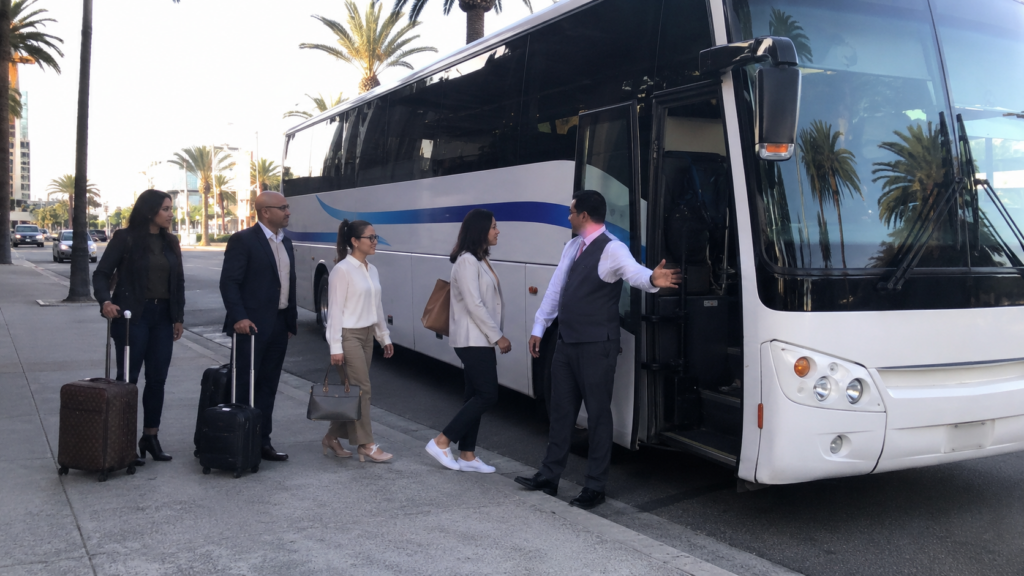 Group of business travelers boarding a charter bus with a professional driver in Los Angeles