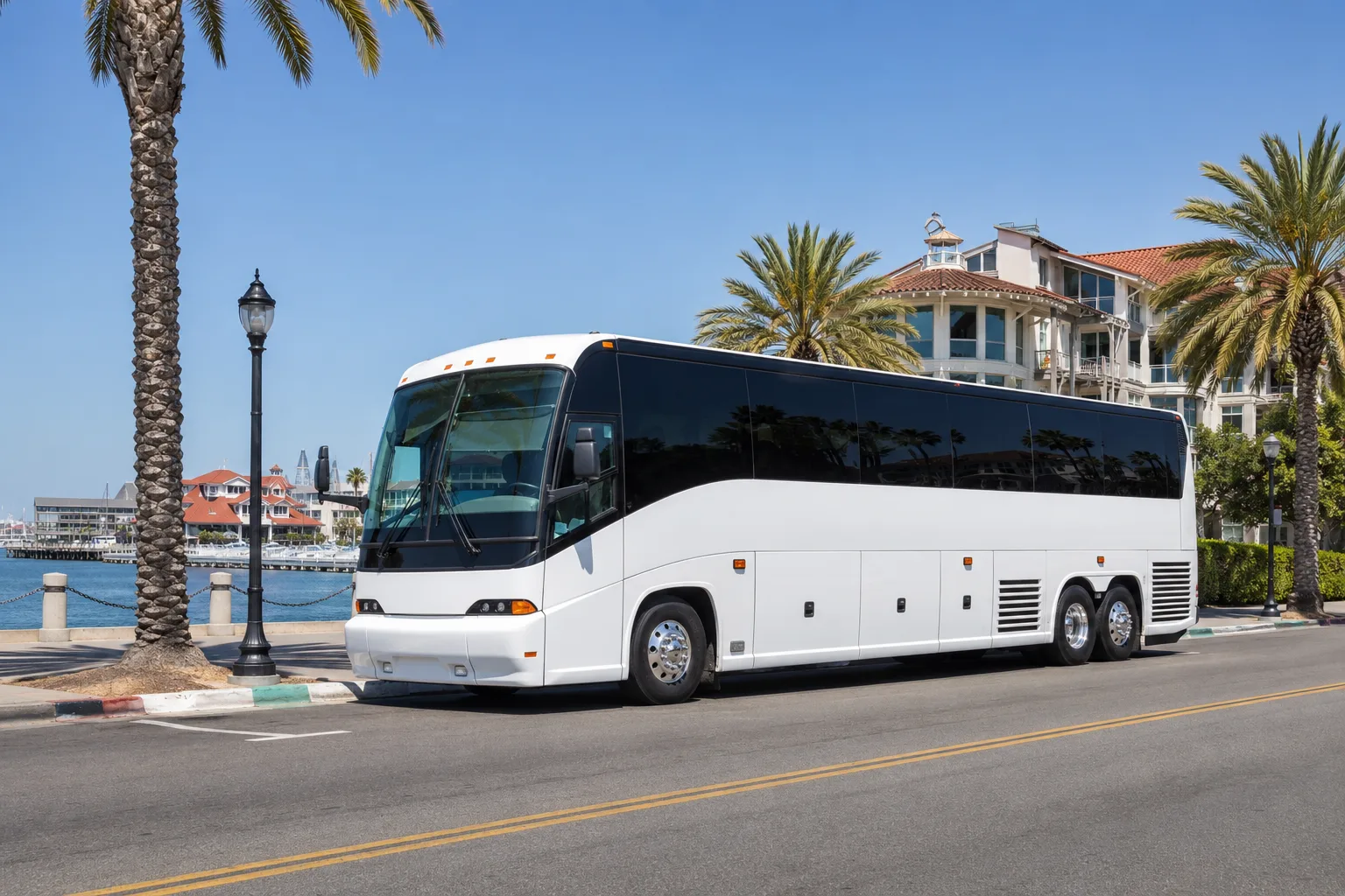 Charter bus parked along a palm-lined San Diego waterfront street after arrival