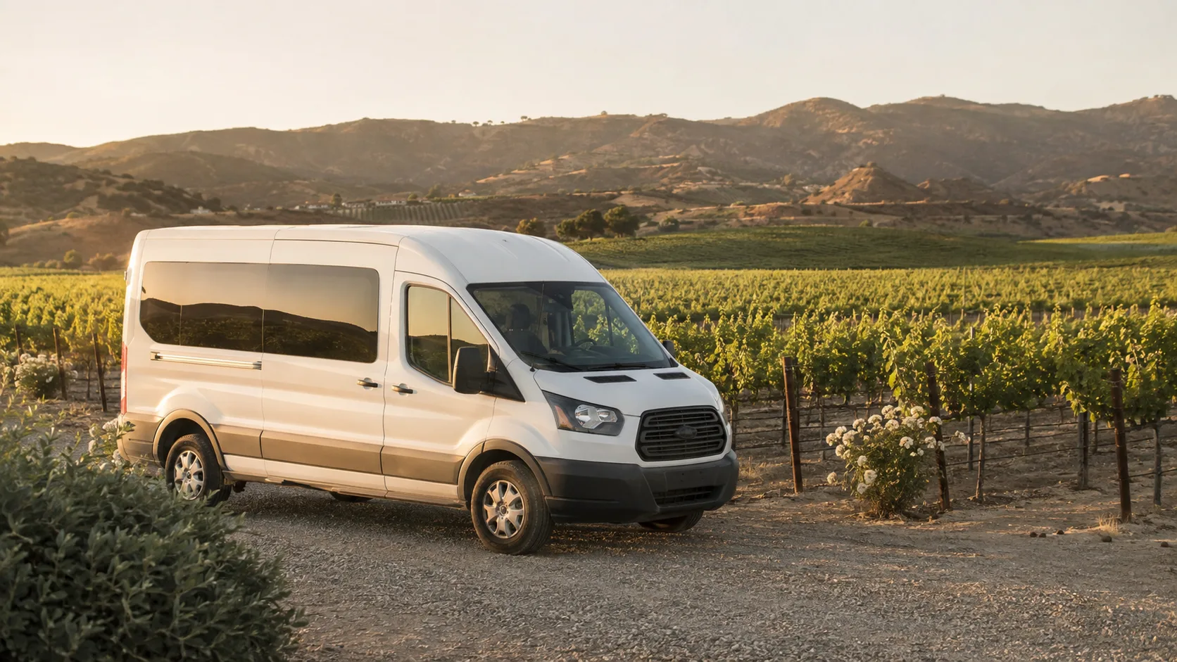 Charter shuttle parked among Temecula Valley vineyard rows at golden hour for a wine tour group trip